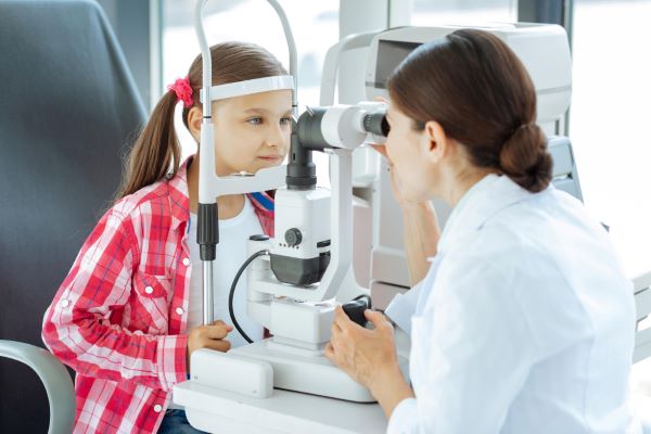 Menina realiza exame oftalmológico para garantir sua saúde ocular.