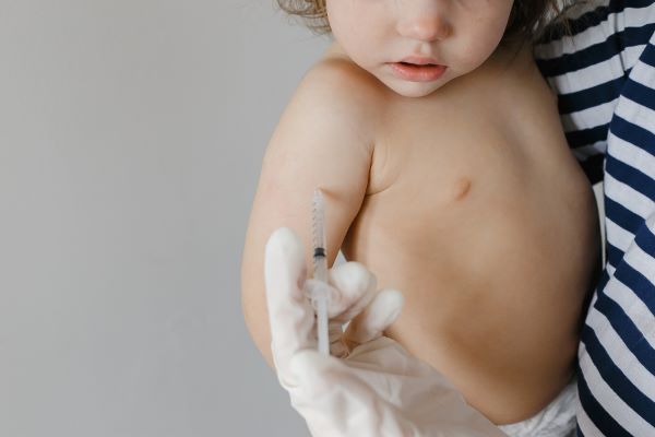 Pediatra vacina criança pequena contra o sarampo.