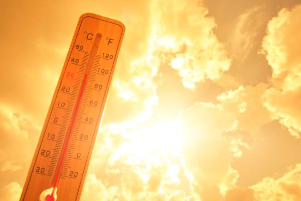 Termômetro, contra fundo de sol forte e amarelo, demonstra a alta temperatura.
