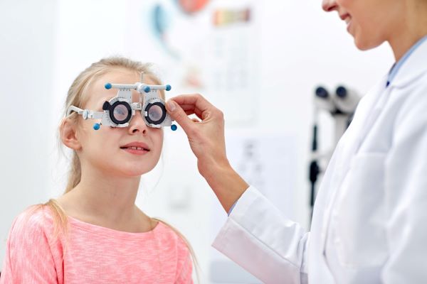 Menina sendo avaliada por oftalmologista como forma de prevenção da DMRI.