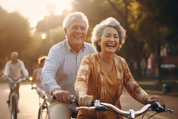 Casal de idosos, felizes, passeiam de bicicleta pelo parque