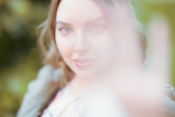 Imagem embaçada de uma jovem em um parque.
Um dos sintomas de doenças de córnea é o embaçamento visual.