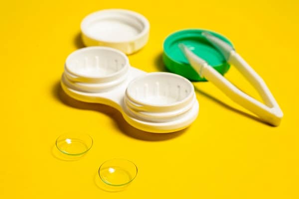 Cuidados com as lentes de contato - na imagem vemos um estojo de acondicionar lentes e a pinça para pegá-las.